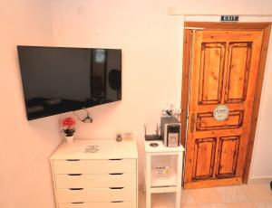 a room with a dresser and a television on the wall at Off Grid Romance in Samos in Ireon