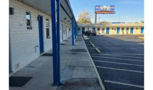 an empty parking lot with blue poles in front of a building at Holiday Motel Ocala Downtown I-75 in Ocala