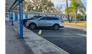 a silver car parked in a parking lot at Holiday Motel Ocala Downtown I-75 in Ocala