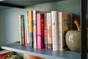 a shelf with a bunch of books and a vase at The Nest in Ruse