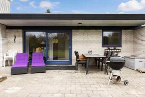 a patio with purple chairs and a grill and a table at 3076-Stege-Rusen-16 in Stege