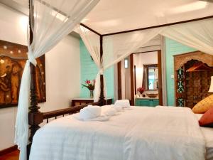 a bedroom with a large white bed with white sheets at Villa Sunrise - Golden Beachfront in Nathon Bay +100 photos