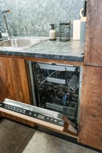 an open dishwasher in a kitchen next to a sink at The Nest in Ruse