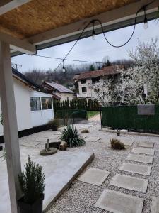 a backyard with a stone patio with a fence at Kuća za odmor MERLIN HOUSE in Vrnjačka Banja
