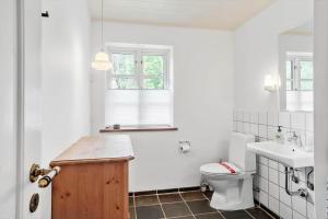 a white bathroom with a toilet and a sink at 2031-Stege-Ulvshalevej-301 in Stege +12 photos