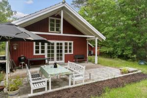 a red house with a picnic table and two chairs at 2031-Stege-Ulvshalevej-301 in Stege