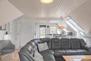 a living room with a leather couch and a kitchen at 1311-Stege-Rylevej-20 in Stege