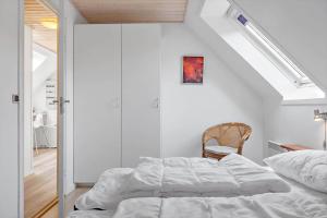 a white bedroom with a bed and a staircase at 1311-Stege-Rylevej-20 in Stege