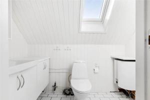a white bathroom with a toilet and a window at 1311-Stege-Rylevej-20 in Stege +12 photos
