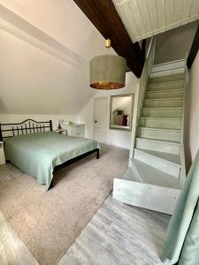 a bedroom with a bed and a staircase and a chandelier at MurMur Chalet in Breaza