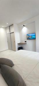 a bedroom with a large white bed with a tv on the wall at Élégant appartement de 3 chambres vue piscine n4 in M'diq +68 photos
