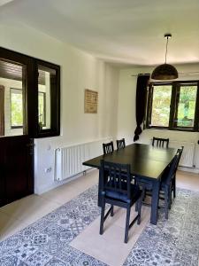 a dining room with a black table and chairs at MurMur Chalet in Breaza