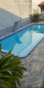 a large swimming pool with a chair in a yard at SR Hotel e Pousada Pirambu in Pirambu