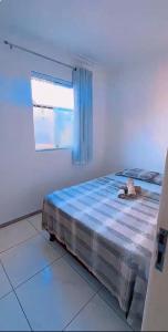 a bed in a white room with a window at SR Hotel e Pousada Pirambu in Pirambu