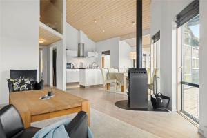 a living room with a table and a kitchen at 1306-Stege-Kaerhogevej-64 in Stege +15 photos