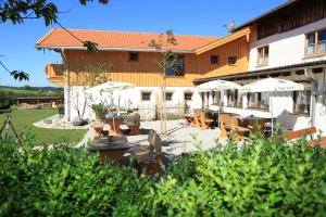 a building with a patio with chairs and umbrellas at Pension Schweizerhaus Garni in Weyarn