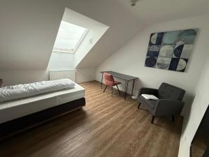 a bedroom with a bed and a desk and a chair at TRUST Boardinghouse in Stuttgart