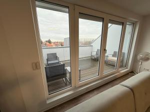 a room with a large window with a view of a balcony at TRUST Boardinghouse in Stuttgart