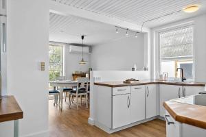 a kitchen with white cabinets and a dining room at 4019-Stege-Udbyvej-15 in Stege