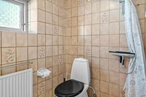 a bathroom with a toilet with a black seat at 4019-Stege-Udbyvej-15 in Stege +14 photos