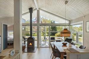a living room with a table and a fireplace at 1080-Stege-Berberisvej-48 in Stege +19 photos