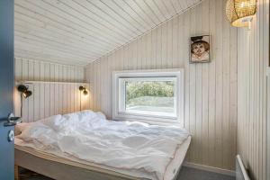 a white bed in a room with a window at 1080-Stege-Berberisvej-48 in Stege