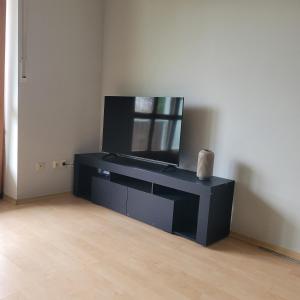 a living room with a tv and a black desk at Moderne 2 Zimmer Appartement in Straubing