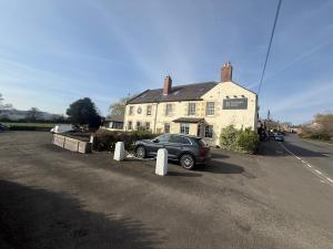 a car parked in front of a house at Hadrians Hotel in Chesters