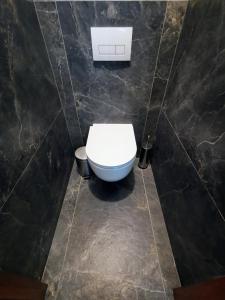 a bathroom with a white toilet in a black wall at Wolkrova city stay in Bratislava