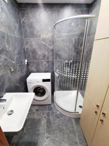 a bathroom with a shower and a washing machine at Wolkrova city stay in Bratislava
