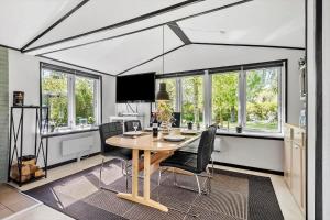 a dining room with a table and chairs and windows at S722-Stroby-Ladeplads-Svalemosevej-36 in Strøby Ladeplads +15 photos