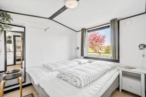 a white bedroom with a bed and a window at S722-Stroby-Ladeplads-Svalemosevej-36 in Strøby Ladeplads