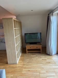 a living room with a flat screen tv and a wooden table at Retreat in Cardiff