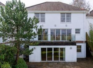 a white house with a tree in front of it at Retreat in Cardiff
