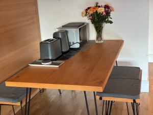 a wooden table with two printers and a vase of flowers at Retreat in Cardiff