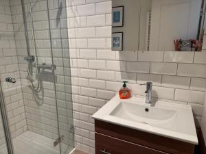 a white bathroom with a sink and a shower at Oland Whg 3 Bi de Meere in Wyk auf Föhr