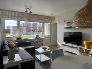 a living room with a couch and a tv at Oland Whg 3 Bi de Meere in Wyk auf Föhr +6 photos