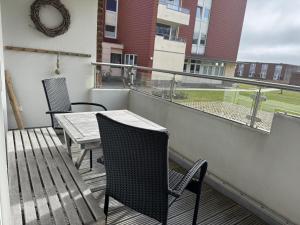 a balcony with a table and chairs and a view of a field at Oland Whg 3 Bi de Meere in Wyk auf Föhr