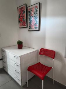 a red chair sitting next to a white dresser at Residenza Frontemura in Montefalco