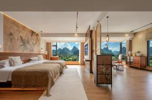 a bedroom with a large bed and large windows at Meadowscape Resort at Yulong River - Karst Views & Infinity Pool & Tickets Reservation Service & Free Laundry in Yangshuo +83 photos