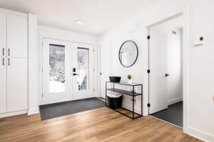 an empty living room with white walls and a mirror at Chalet Mysa Spa Lac access Firepit pit SKI in Saint Come