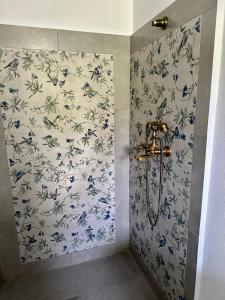 a bathroom with a shower with blue and white wallpaper at MurMur Chalet in Breaza +26 photos