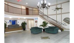 a living room with two chairs and a staircase at Regency Inn & Suites Houston East I 10 in Houston