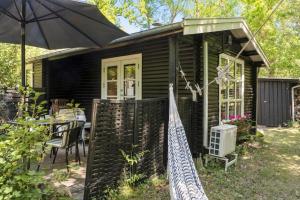 a small house with a table and an umbrella at 2025-Stege-Ulvshalevej-319 in Stege