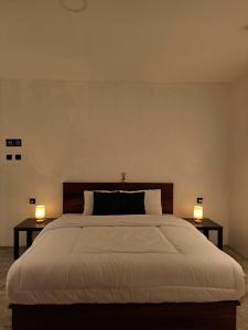 a bedroom with a large bed with two lamps on tables at Second Point View BK in Batukaras