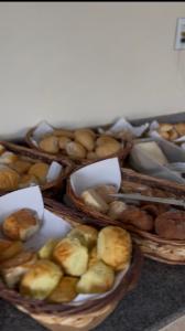 a group of baskets filled with different types of bread at Chalé Vila Catarina in Ouro Preto