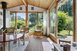 a conservatory with glass doors and a table and chairs at 3055-Stege-Stejlepladsen-23 in Stege