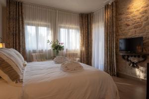 a bedroom with a white bed with towels on it at Alistos Hotel in Gythio