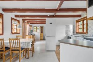 a kitchen with a table and chairs in a room at S705-Stroby-Hybenvej-1 in Strøby