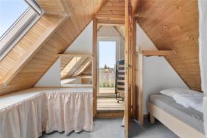 a small attic bedroom with a bed and a window at S705-Stroby-Hybenvej-1 in Strøby